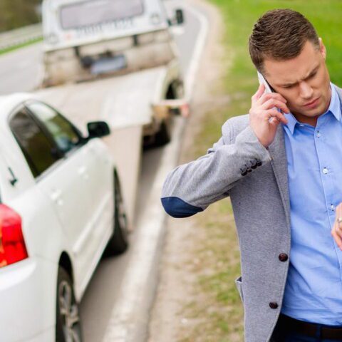 A man on the phone near an accident scene.