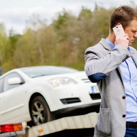 A man on the phone near a car.
