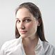 A woman in white shirt looking at camera.