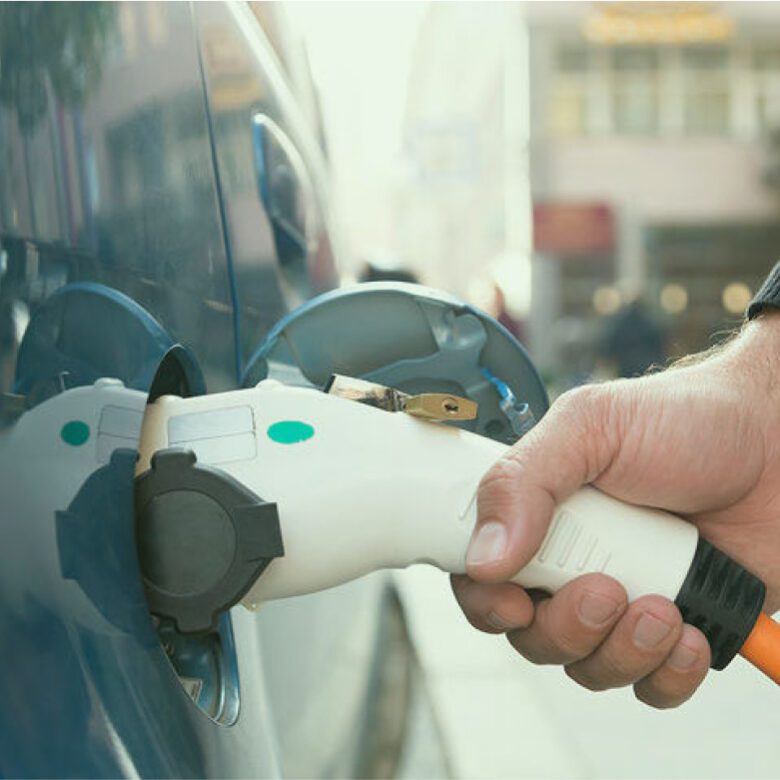 A person charging an electric car at the charger.