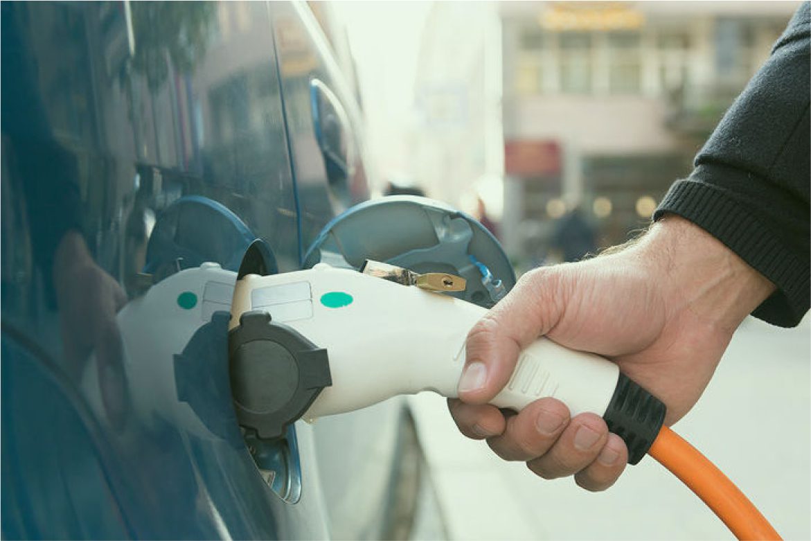 A person charging an electric car at the charger.