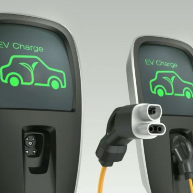 Two electric cars are plugged in to charge.